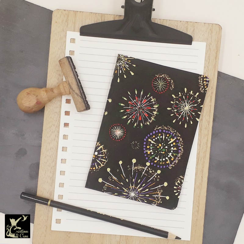 Carnet de notes au format très pratique A6. La couverture est recouverte à la main d’un papier japonais au fond noir, décoré de feux d'atifices colorés.