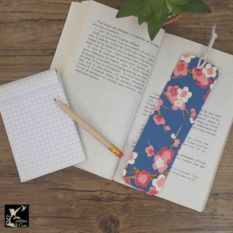 Ne perdez plus le fil de vos lectures ! Ce marque-page artisanal, recouvert d'un élégant papier japonais bleu marine orné de sakura deviendra votre allié.