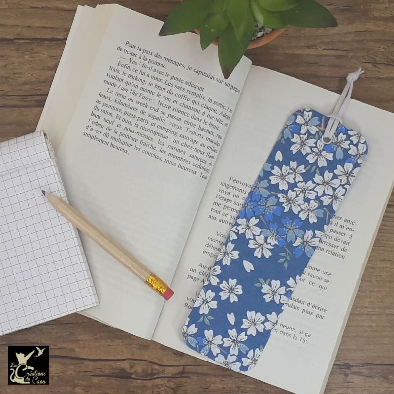 Ne perdez plus le fil de vos lectures ! Ce marque-page artisanal, recouvert d'un élégant papier japonais bleu marine orné de fleurs deviendra votre allié.