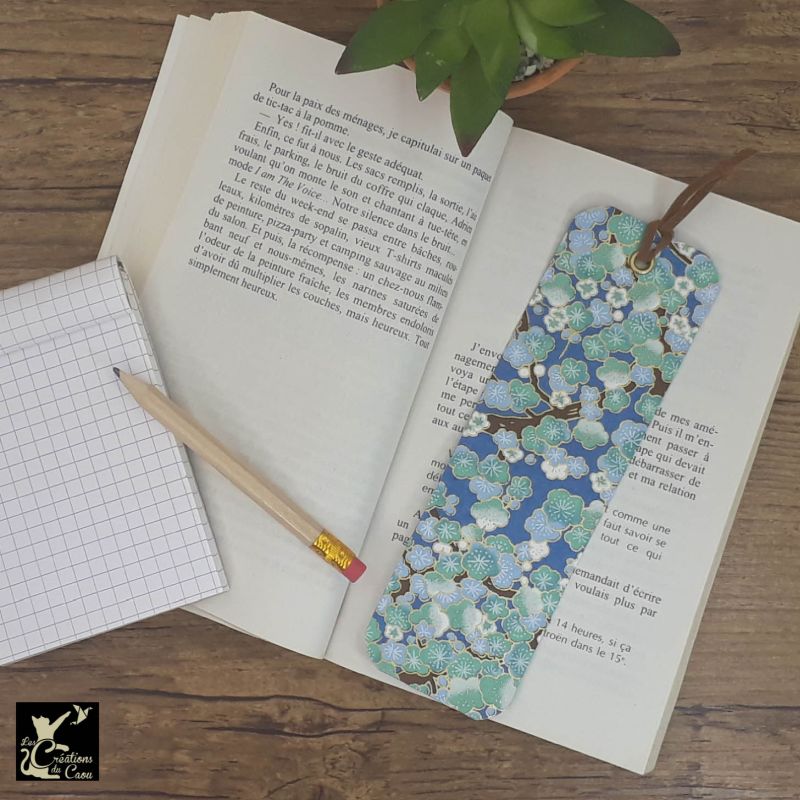 Ne perdez plus le fil de vos lectures ! Ce marque-page artisanal, recouvert d'un élégant papier japonais bleu foncé orné de fleurs de prunier deviendra votre allié.