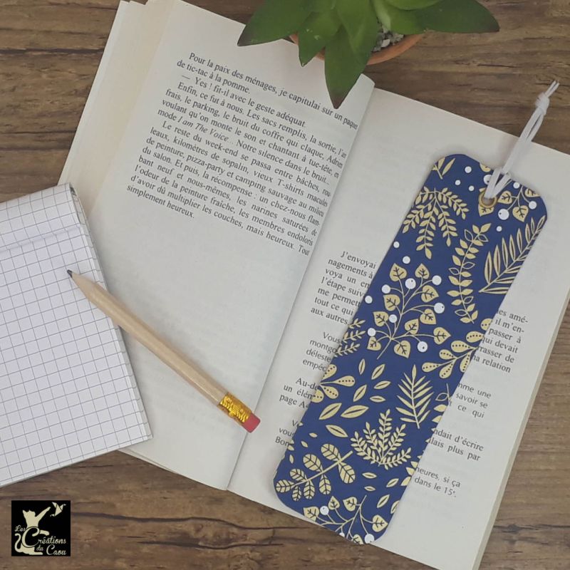 Ne perdez plus le fil de vos lectures ! Ce marque-page artisanal, recouvert d'un élégant papier japonais bleu foncé orné de végétaux dorés deviendra votre allié.