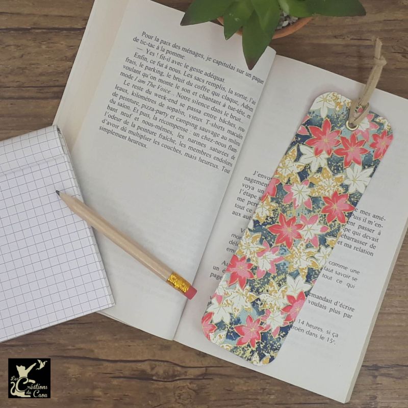 Ne perdez plus le fil de vos lectures ! Ce marque-page artisanal, recouvert d'un élégant papier japonais orné de feuilles aux tons moutarde, roses et blanches sur un fond bleu ciel à bleu turquoisedeviendra votre allié.