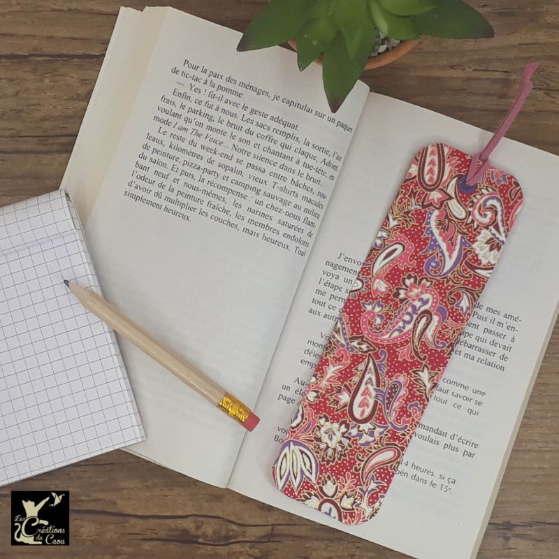 Ne perdez plus le fil de vos lectures ! Ce marque-page artisanal, recouvert d'un élégant papier japonais fuchsia orné de paisley deviendra votre allié.