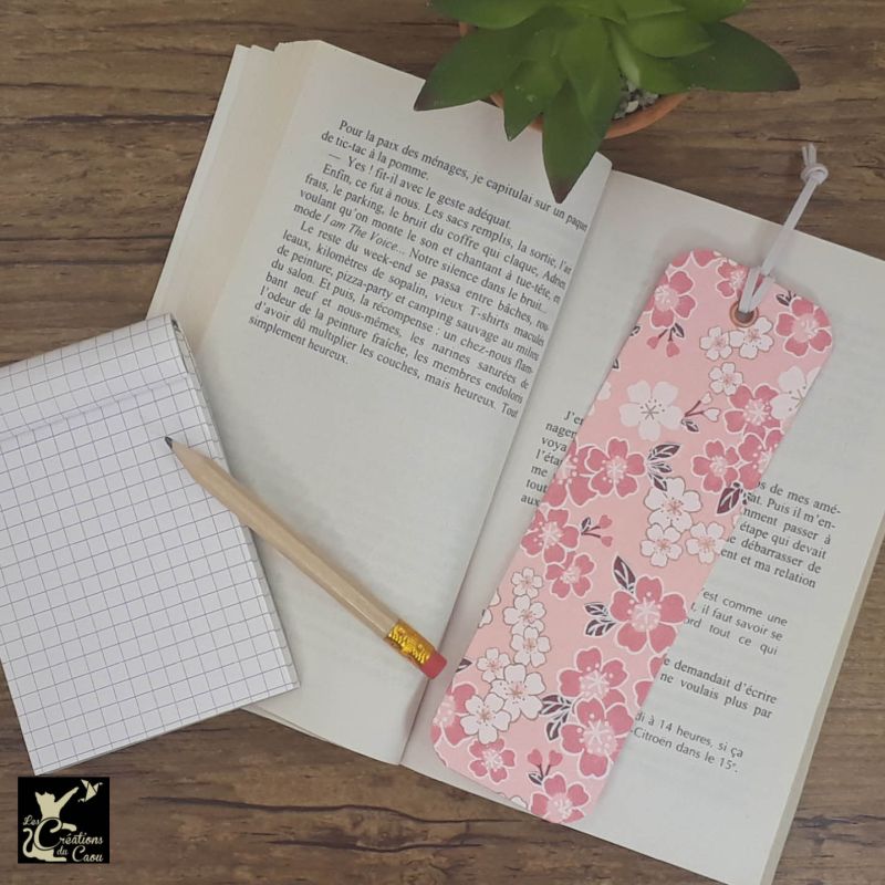 Ne perdez plus le fil de vos lectures ! Ce marque-page artisanal, recouvert d'un élégant papier japonais rose tendre fleuri deviendra votre allié.