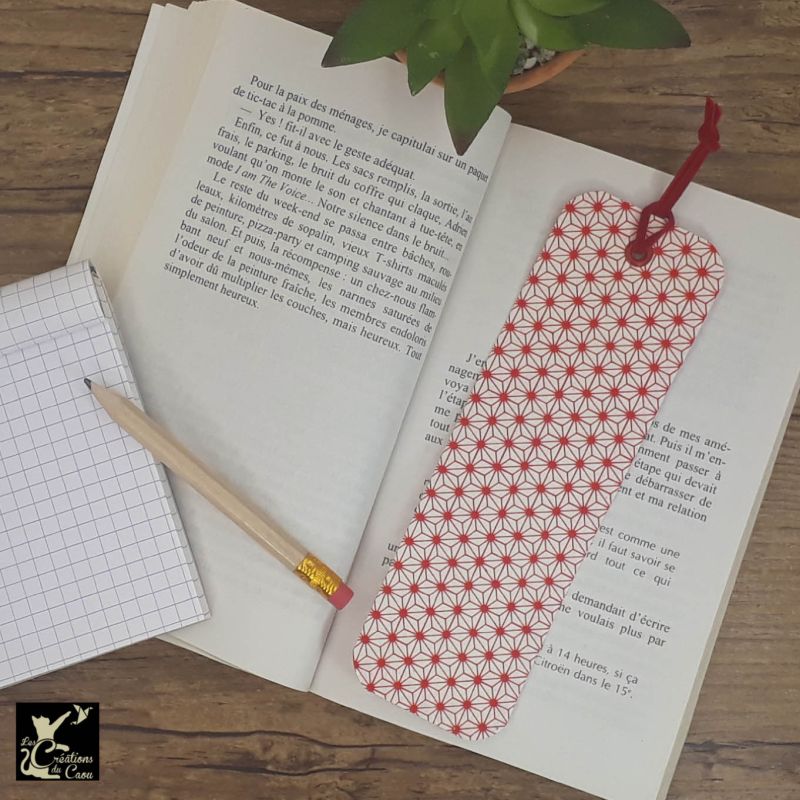 Ne perdez plus le fil de vos lectures ! Ce marque-page artisanal, recouvert d'un élégant papier japonais au motif étoilé rouge deviendra votre allié.