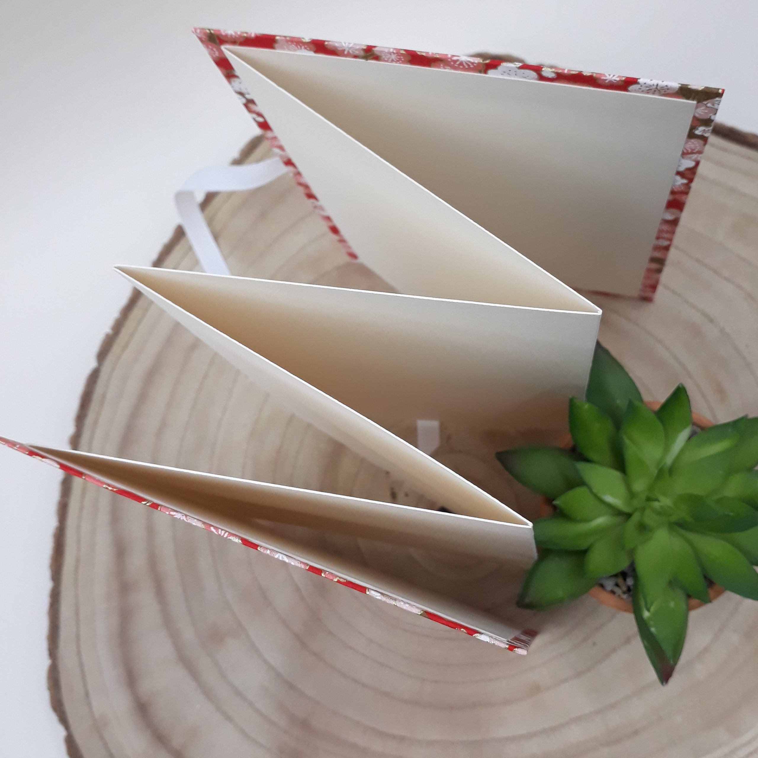 Album photo leporello réalisé à la main dans notre atelier de Lambersart (Lille), recouvert d'un papier japonais rouge au motif de fleurs de prunier.