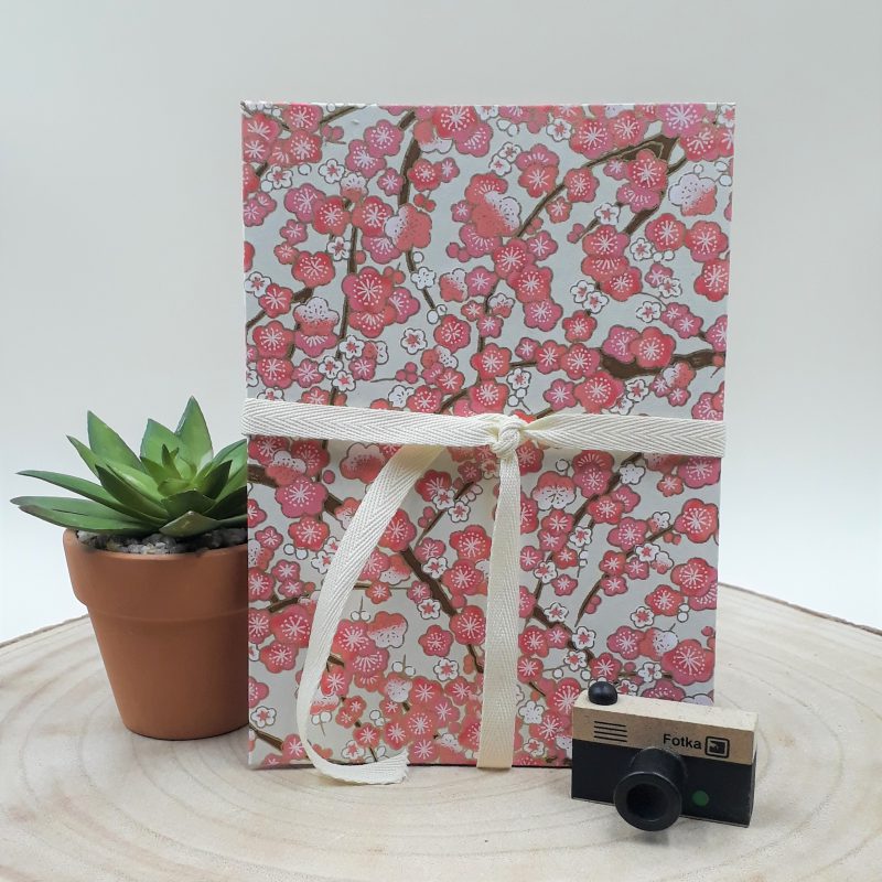 Album photo leporello réalisé à la main dans notre atelier de Lambersart (Lille), recouvert d'un papier japonais écru au motif de fleurs de pruniers roses.