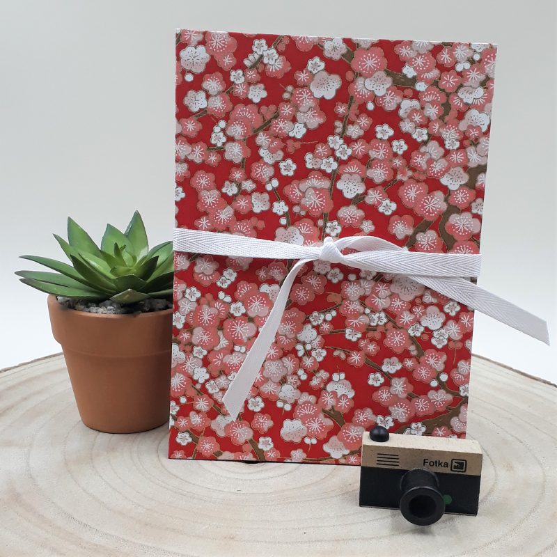 Album photo leporello réalisé à la main dans notre atelier de Lambersart (Lille), recouvert d'un papier japonais rouge au motif de fleurs de prunier.