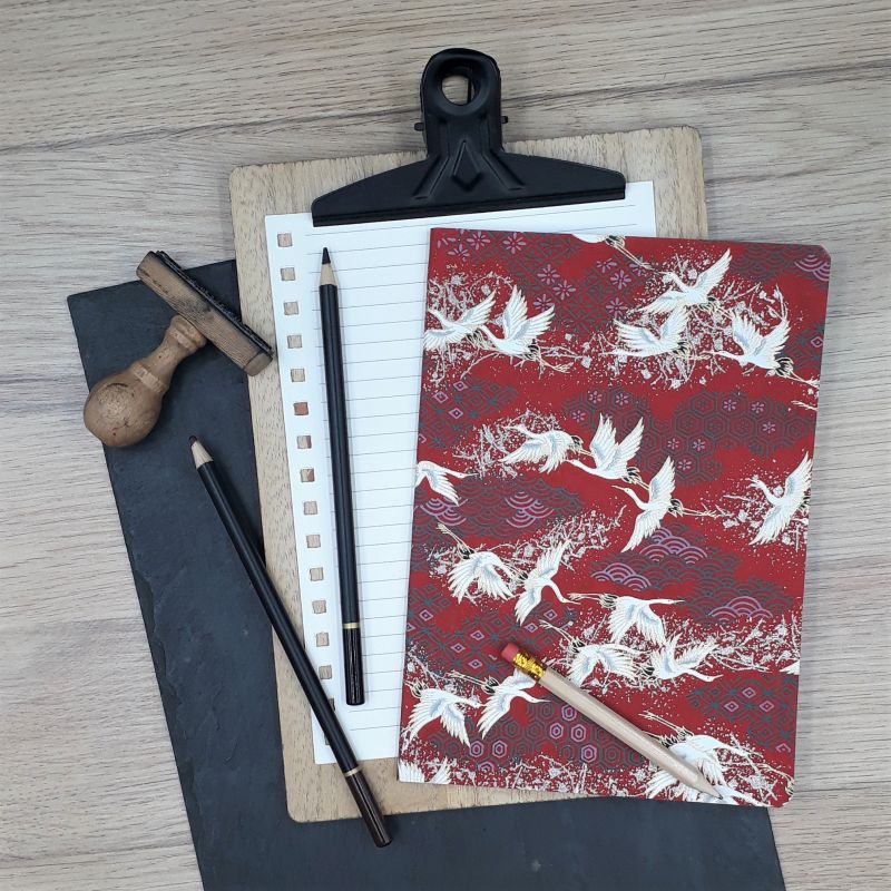 Carnet A5 recouvert à la main d'un papier artisanal japonais bordeaux au motif de grues blanches du Japon.