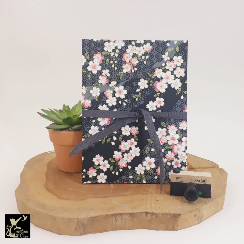 Album photo leporello réalisé à la main dans notre atelier de Lambersart (Lille), recouvert d'un papier japonais noir au motif de sakuras rose et blancs.