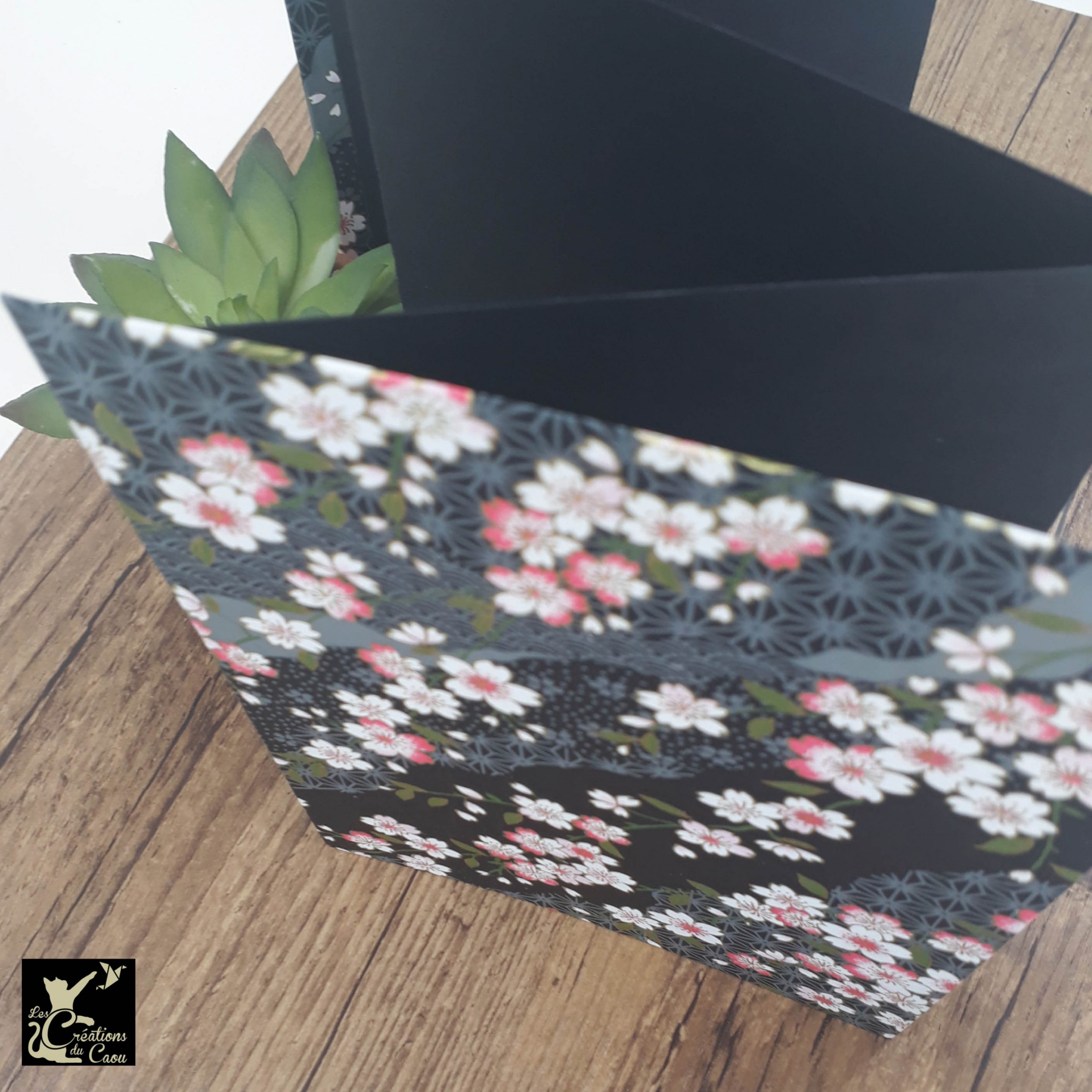 Album photo leporello réalisé à la main dans notre atelier de Lambersart (Lille), recouvert d'un papier japonais noir au motif de sakuras rose et blancs.