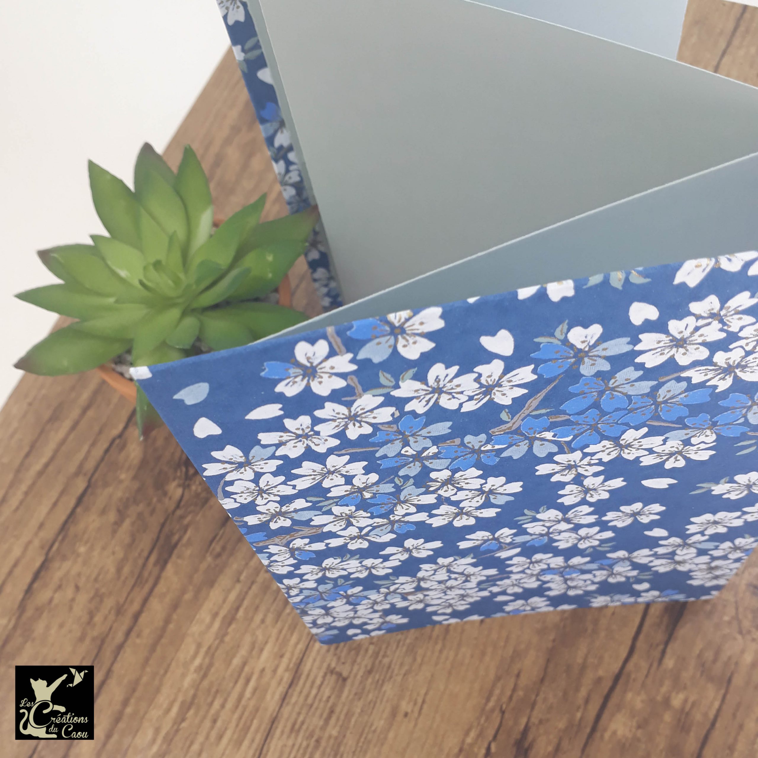 Album photo leporello réalisé à la main dans notre atelier de Lambersart (Lille), recouvert d'un papier japonais bleu marine au motif de sakuras blancs.