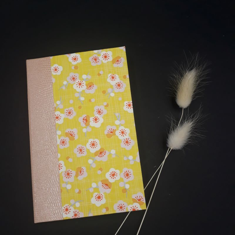 Répertoire de poche réalisé artisanalement recouvert d'un papier japonais jaune fleuri.